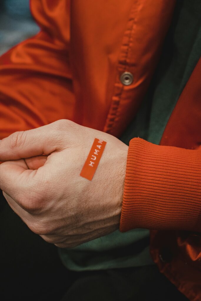 Orange and white textile on someones hand